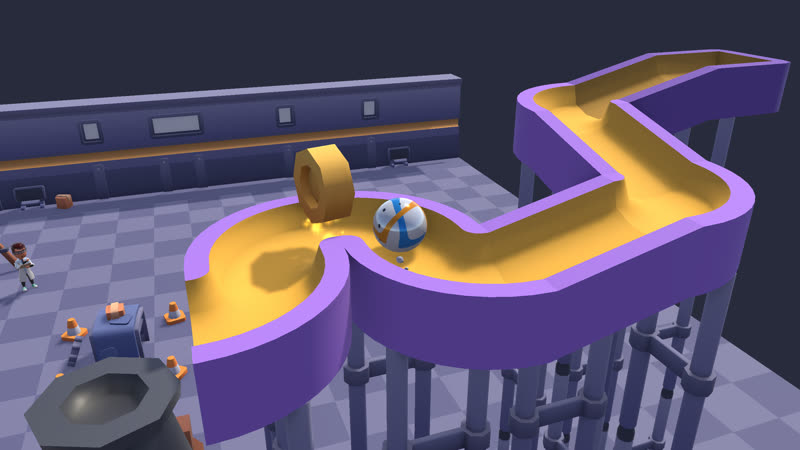 A marble rolling along a winding yellow and purple track high above the workshop floor